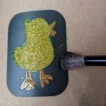 Use the long soft bristles of the Glitter Brush to sweep away excess glitter