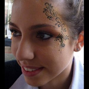 abstract face painting design with Gold glitter gel accents